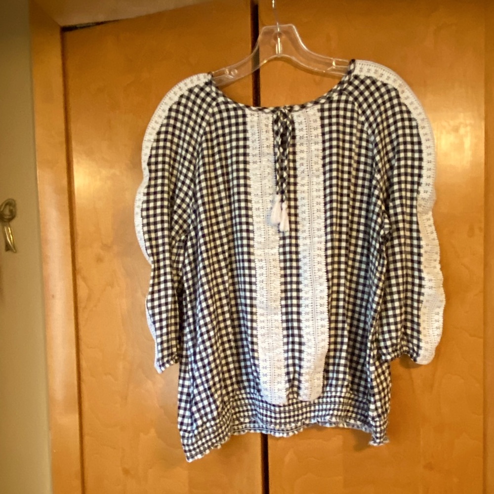 Black white 3/4 sleeve top.  White tassels with front top V.